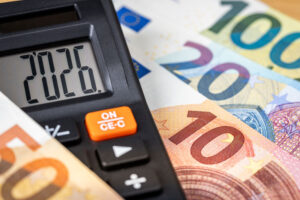Euroscheine auf einem Tisch und ein Taschenrechner darauf mit Datum 2026.